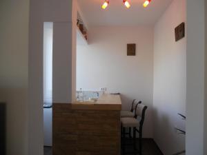a kitchen with a bar with two chairs and a sink at Apartmani Bonaca u Centru Nikšića in Nikšić