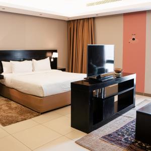 sypialnia z łóżkiem i telewizorem z płaskim ekranem w obiekcie Dara Al Salam w mieście Dżudda