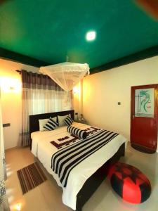 a bedroom with a large bed with a green ceiling at Green Lantern in Ella