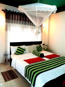 a bedroom with a large bed with green and red pillows at Green Lantern in Ella