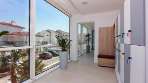 a room with a large window and a balcony at Cool Šilo Appartement Resort in Šilo