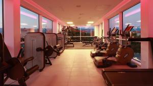 a gym with rows of exercise equipment and windows at Cool Šilo Appartement Resort in Šilo