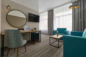 a waiting room with a mirror and blue chairs at Aerostar Hotel in Moscow