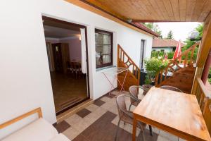 a room with a table and chairs on a balcony at Apartments U Jezera Černá in Černá v Pošumaví
