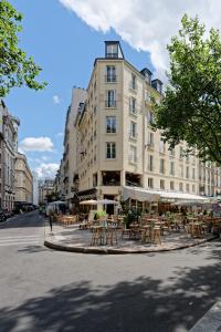 um edifício com mesas e cadeiras numa rua em My Maison In Paris - Louvre em Paris