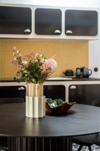 een vaas met bloemen op een tafel in een keuken bij My Maison In Paris - Louvre in Parijs