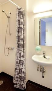 a bathroom with a sink and a shower at Lillehammer Stasjonen Hostel in Lillehammer