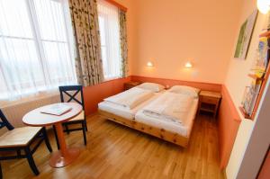 a bedroom with a bed and a small table and a table sidx sidx at JUFA Hotel Hochrindl in Hochrindl