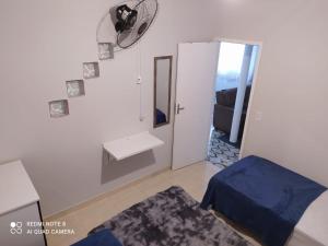 サンタ・テレサにあるKITNET DU VÔのベッド、洗面台、鏡が備わる客室です。
