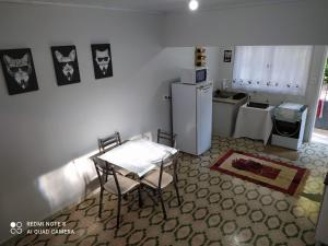 a small kitchen with a table and a refrigerator at KITNET DU VÔ in Santa Teresa