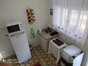 eine kleine Küche mit einer Spüle und einer Mikrowelle in der Unterkunft KITNET DU VÔ in Santa Teresa