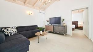 a living room with a black couch and a tv at Villa Leon in Brtonigla