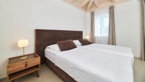 een slaapkamer met een groot wit bed en een nachtkastje bij Villa Leon by Villas Holiday in Brtonigla +25 foto's