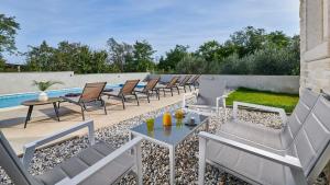 een terras met stoelen en een tafel en een zwembad bij Villa Leon by Villas Holiday in Brtonigla