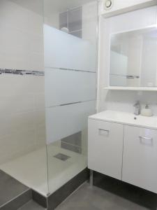 a white bathroom with a sink and a mirror at L Appart Eurexpo & Groupama Stadium 10' in Genas