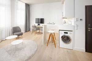 uma cozinha branca com uma máquina de lavar roupa num quarto em Bergmann Boardinghouse Oldenburg em Oldenburg