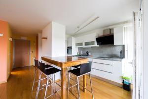 a kitchen with a wooden table and black chairs at Apartman Bruna SELF CHECK-IN in Osijek