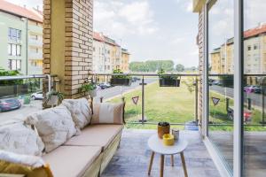 a couch on a balcony with a view of a street at Apartman Bruna SELF CHECK-IN in Osijek