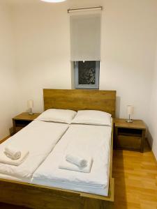 a bedroom with a bed with two towels on it at RIVIERA LIPNO 502 Apartmán 4kk u vody in Lipno nad Vltavou