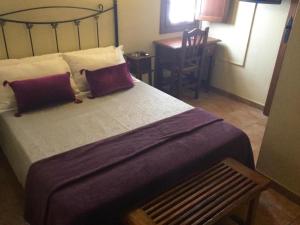 1 dormitorio con 1 cama grande y 1 mesa en Hostal San Pedro, en Cuenca