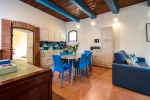 a kitchen and dining room with a table and blue chairs at Castello di Montonate in Mornago +17 photos