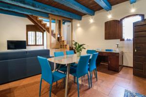 a kitchen and living room with a table and blue chairs at Castello di Montonate in Mornago