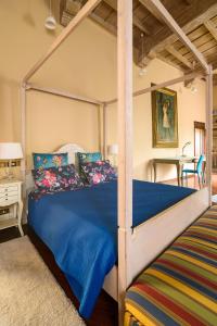 a bedroom with a canopy bed with blue sheets at Castello di Montonate in Mornago