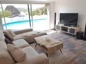 uma sala de estar com um sofá e uma televisão em Suite cocooning - Route des Vins em Bergbieten