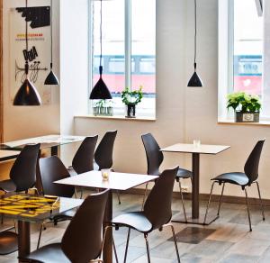 a restaurant with tables and chairs and windows at Lillehammer City Hostel in Lillehammer