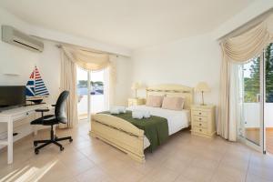 a bedroom with a bed and a desk and a computer at Casa de Gales - Vilamoura in Vilamoura