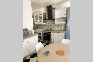 a kitchen with a table and white cabinets at Appartement cosy in Vannes
