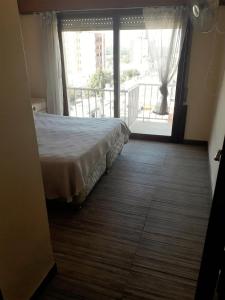 1 dormitorio con cama y ventana grande en Departamento Céntrico en Villa Carlos Paz