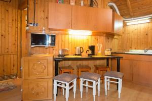 uma cozinha com armários de madeira e um balcão com bancos em Rustic Regal em Sinaia