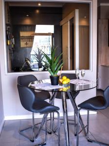 a dining room table with chairs and a plant on it at Red Velvet - Lux One Bedroom in Pretoria