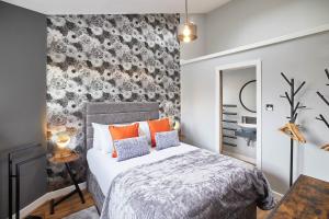 a bedroom with a bed with orange pillows at Host & Stay - 82 Galgate in Barnard Castle