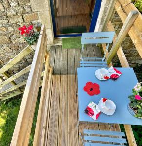- une table et des chaises sur une terrasse fleurie dans l'établissement Les Coquelicots, à Saint-Urbain