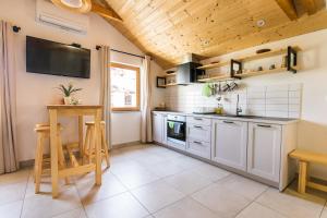 a kitchen with white appliances and a wooden ceiling at Pr' Petrču in Tolmin