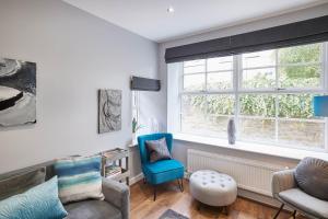 a living room with a blue chair and a window at Host & Stay - 82 Galgate in Barnard Castle