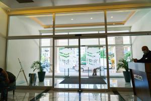 Ein Mann steht vor einer Glastür. in der Unterkunft Batumi Orbi City Twin Towers C-block 2659 in Batumi