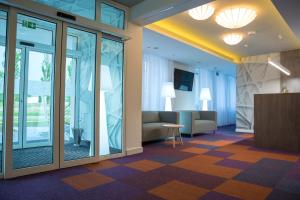 a lobby with glass doors and a waiting area at Hotel Quattro in Szczecinek