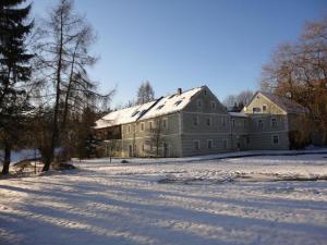ein großes Gebäude mit Schnee auf dem Boden in der Unterkunft Hendlmühle in Wondreb