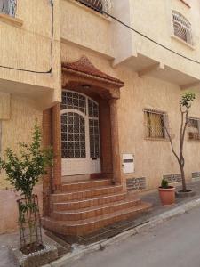 a building with a white door and stairs in front at Comfortable home in middle Atlas in Azrou