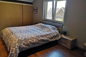 Schlafzimmer mit einem Bett und einem Fenster in der Unterkunft ARd&d : spacieux Gîte rural - 3 épis / 6 personnes in Malonne
