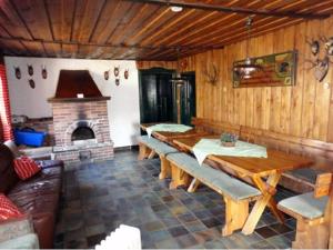 ein Esszimmer mit Holztischen und einem Kamin in der Unterkunft Hendlmühle in Wondreb