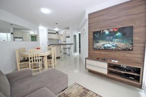 ein Wohnzimmer mit einem großen Flachbild-TV an der Wand in der Unterkunft Residencial Frederico in Bombinhas