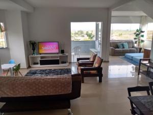 a living room with a couch and a tv at Casa Bela Vista in Penedo