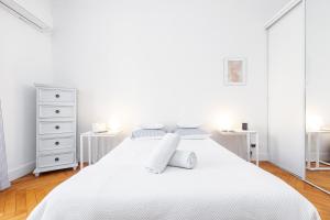 ein weißes Schlafzimmer mit einem weißen Bett und 2 Schreibtischen in der Unterkunft FEEL HOME - GRIMALDI in Nizza