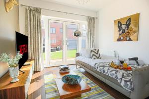 a living room with a couch and a table at Luxury House with Pool Table, Smart TVs, Garden and Free Parking by Yoko Property in Milton Keynes