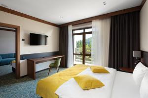 a hotel room with a bed and a desk at Ведмежа гора Hotel & Spa in Yaremche