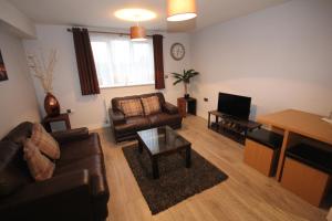 a living room with a couch and a table at Holden Court Apartments - Apt 3 in West Drayton